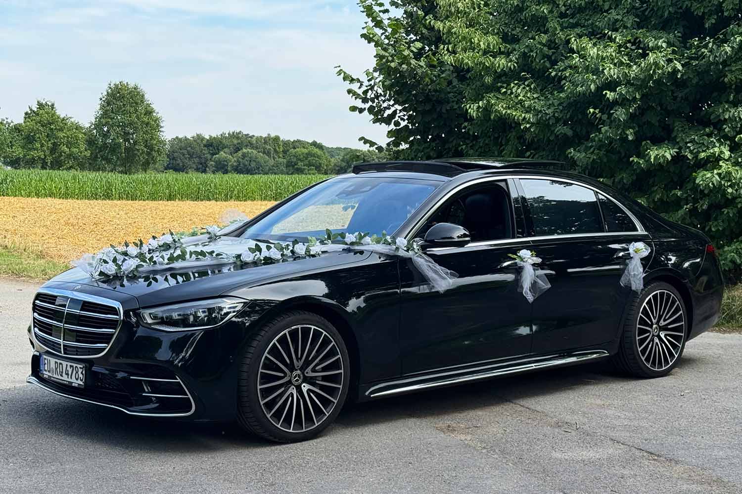 Seitliche Ansicht Hochzeitsauto - Mercedes Benz S-Klasse S580 in schwarz mit Kunstblumen | Autovermietung Arndt