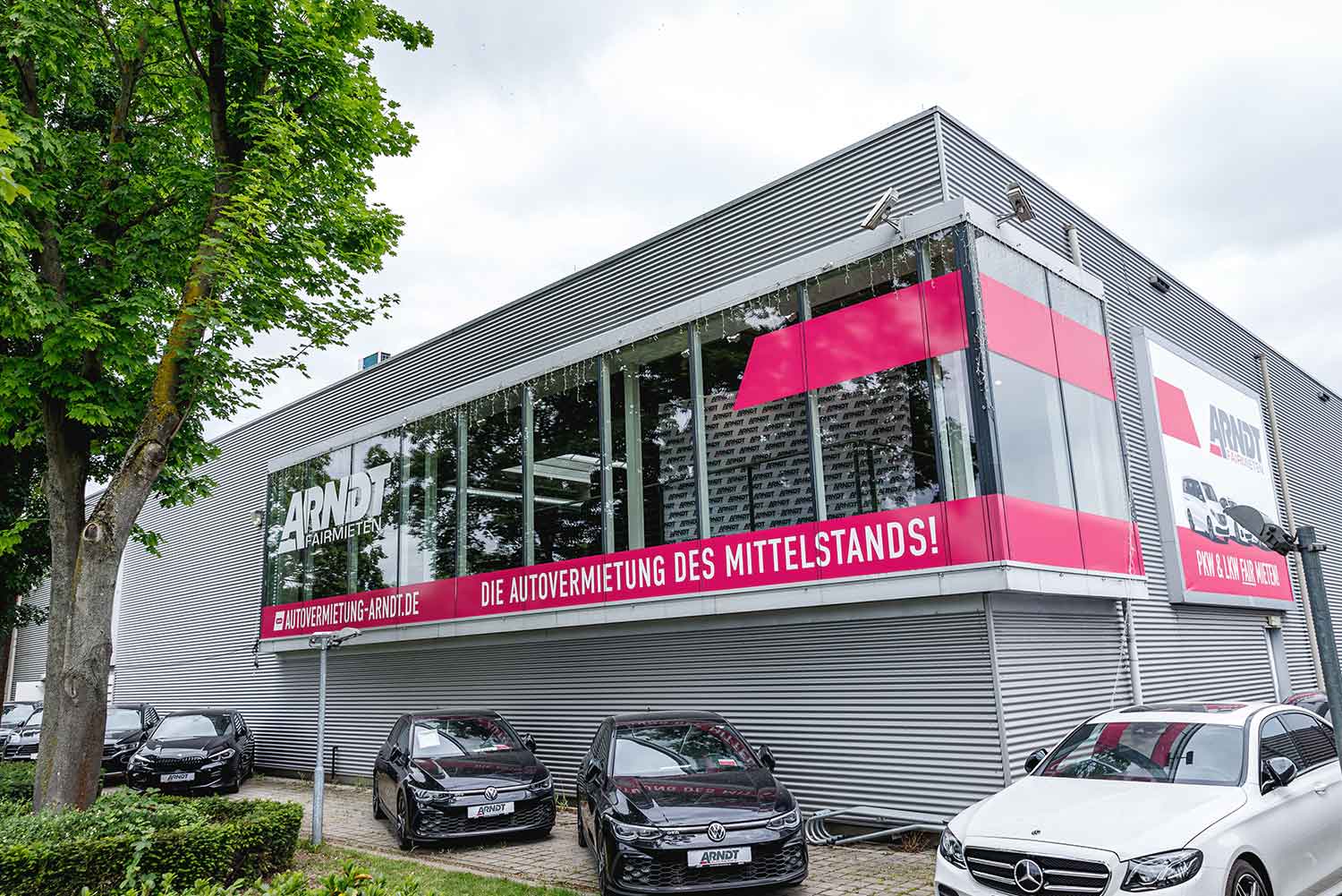 Außenansicht der Arndt Station in Neuss mit mehreren geparkten Autos | Autovermietung Arndt